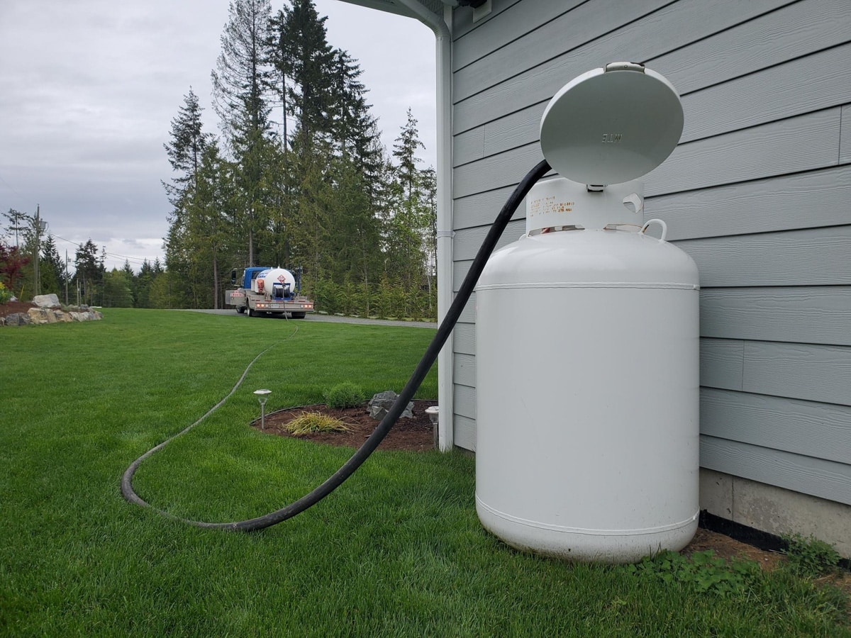Propane tank with delivery truck nearby: propane delivery on Vancouver Island