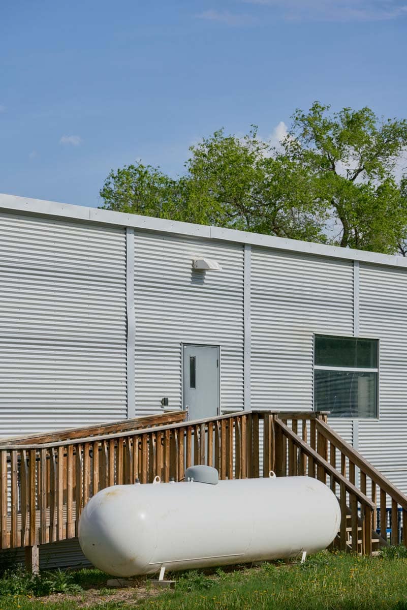 White propane tank sales and installation near building
