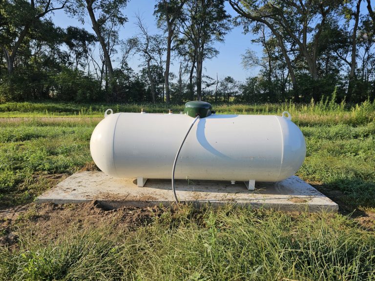 White propane tank in grassy field